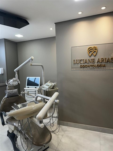 Cadeira odontológica e placa com o nome Luciane Arias